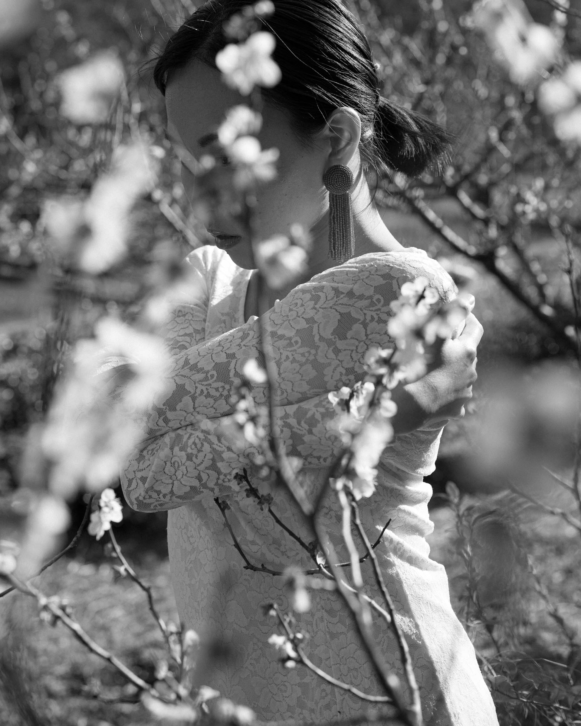 ayaをモデルに、和田剛が撮影したポートレート作品「somewhere」。季節の花とモデルを撮影したモノクロームの人物写真。